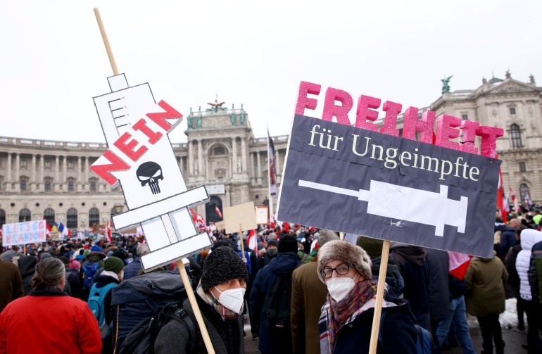 Demonstrators hold flags and placards against COVID vaccines in Austria's Vienna