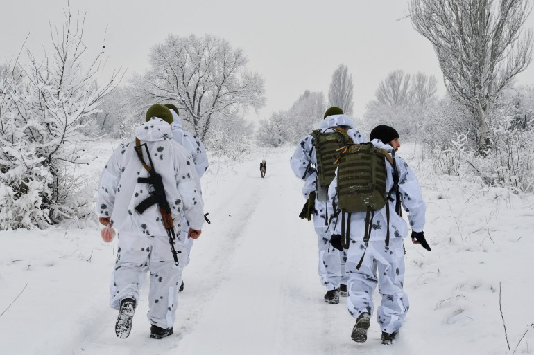 Ukrainian servicemen walk to their position at the frontline