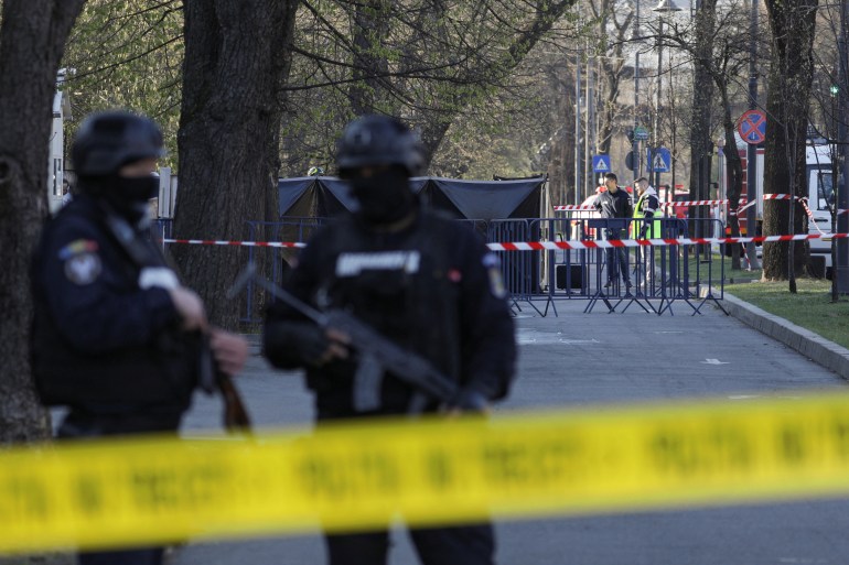 Police officers are seen standing guard at the crime scene in Bucharest