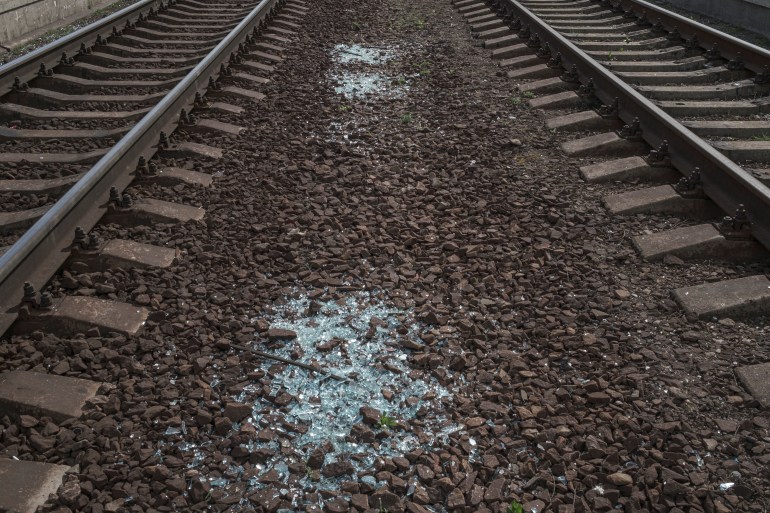 Shards of glass from broken train windows are seen at a railway station
