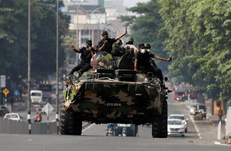 Army members travel on an armoured car on a main road in Colombo, Sri Lanka.