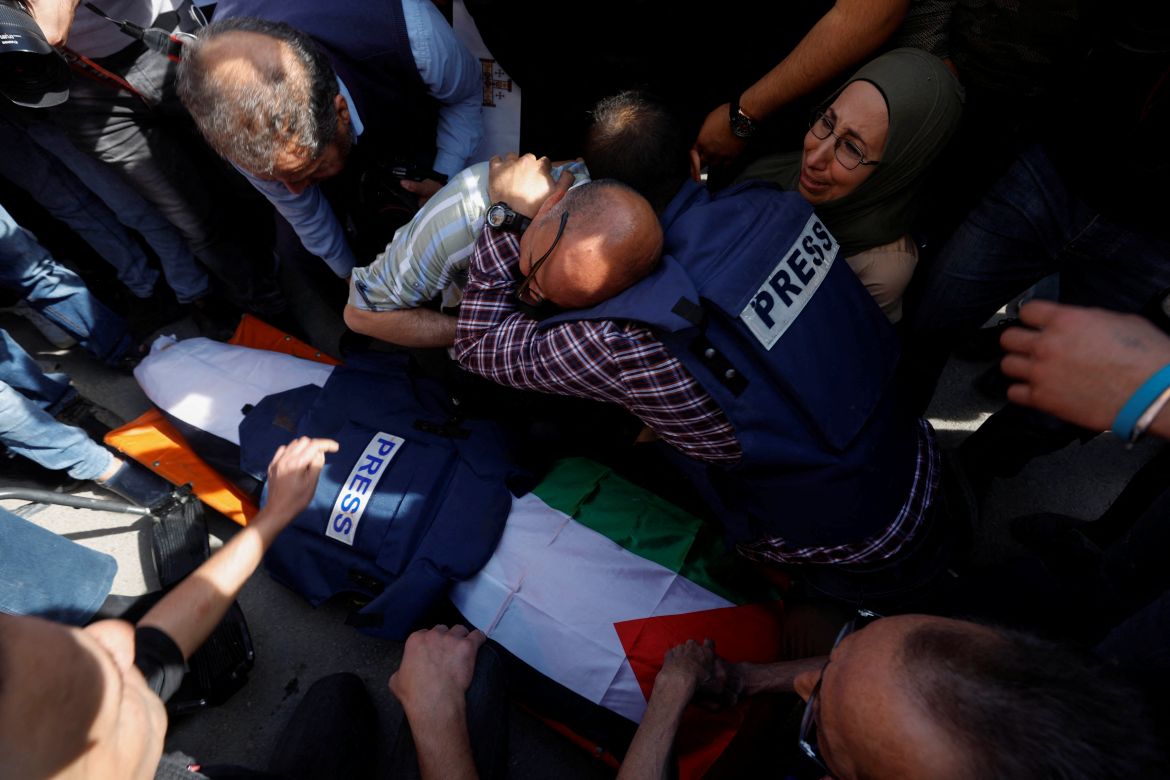 Mourners, including Journalists, react next to the body of Al Jazeera reporter Shireen Abu Akleh