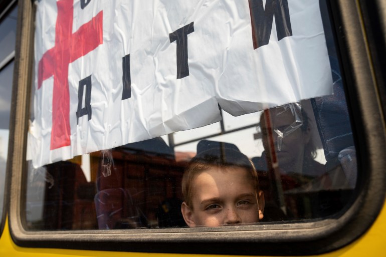A boy from Siversk looks though the window of a bus during evacuation near Lyman, Ukraine, Wednesday, May 11, 2022