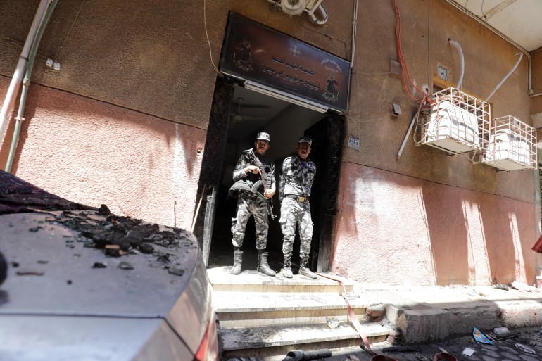 Security members stand at the scene where a deadly fire broke out at the Abu Sifin church in Giza, Egypt