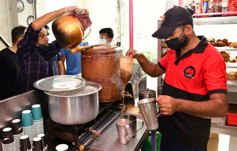 A tea maker pour decoction into the milk from a cloth sieve in the final phase of making samovar tea