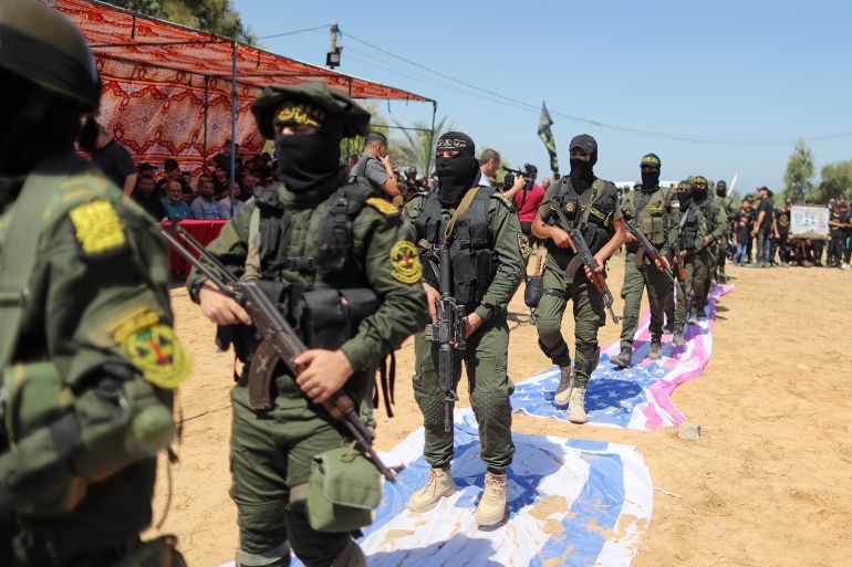 Islamic Jihad militants step on replicas of Israeli and U.S. flags during a graduation ceremony for young Palestinians at a military summer camp organised by the Islamic Jihad Movement, in Gaza City June 30, 2021. REUTERS/Suhaib Salem