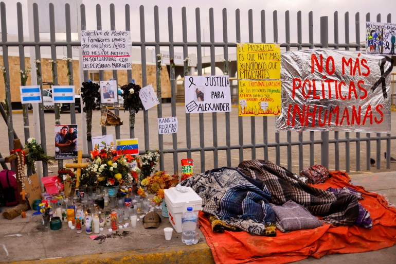 Migrants sleep next to an altar outside the migrant detention centre where dozens killed