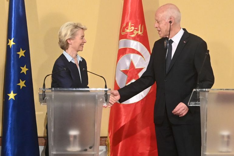 This handout picture provided by the Tunisian Presidency Press Service shows European Commission President Ursula Von der Leyen shakes the hand of Tunisia's President Kais Saied after a press briefing