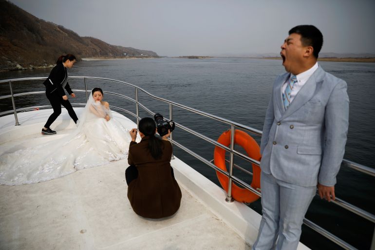 A couple gets ready for their wedding photo session on a boat that takes tourists from Chinese side of the Yalu River for sightseeing close to the shores of North Korea, near Dandong, China's Liaoning province, March 30, 2017. REUTERS/Damir Sagolj SEARCH "DANDONG BORDER" FOR THIS STORY. SEARCH "WIDER IMAGE" FOR ALL STORIES.