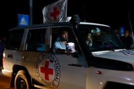 A Red Cross vehicle, as part of a convoy carrying captives held in Gaza, arrives at the Rafah border [Ibraheem Abu Mustafa/Reuters]
