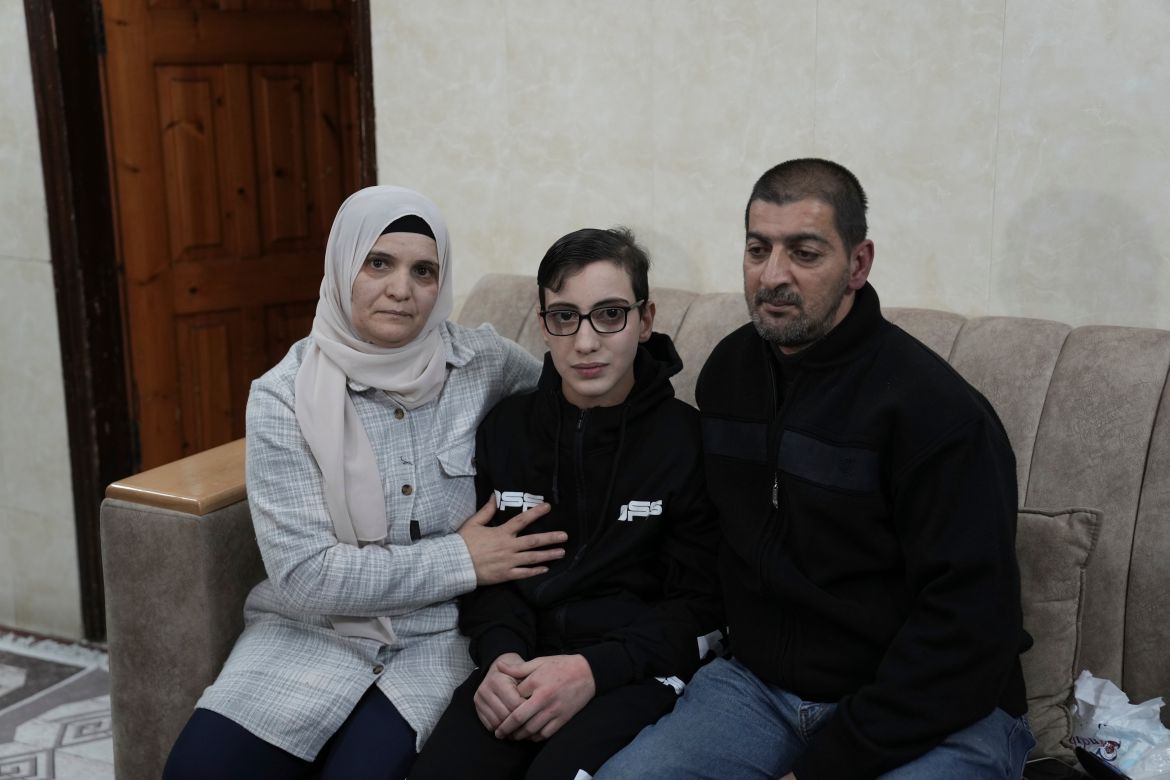 Moataz Salaima, 15, center, a Palestinian prisoner released by Israel, poses for a photo with his parents as he arrives home in the east Jerusalem neighborhood of Ras al-Amud.