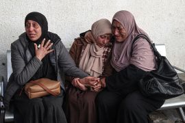 Palestinians mourn over the covered bodies of relatives, killed in overnight Israeli bombardment, at the al-Najjar hospital in Rafah [Said Khatib/AFP]