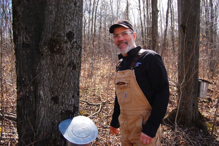 Quebec maple syrup producer Jean-Francois Touchette stands next to a maple tree